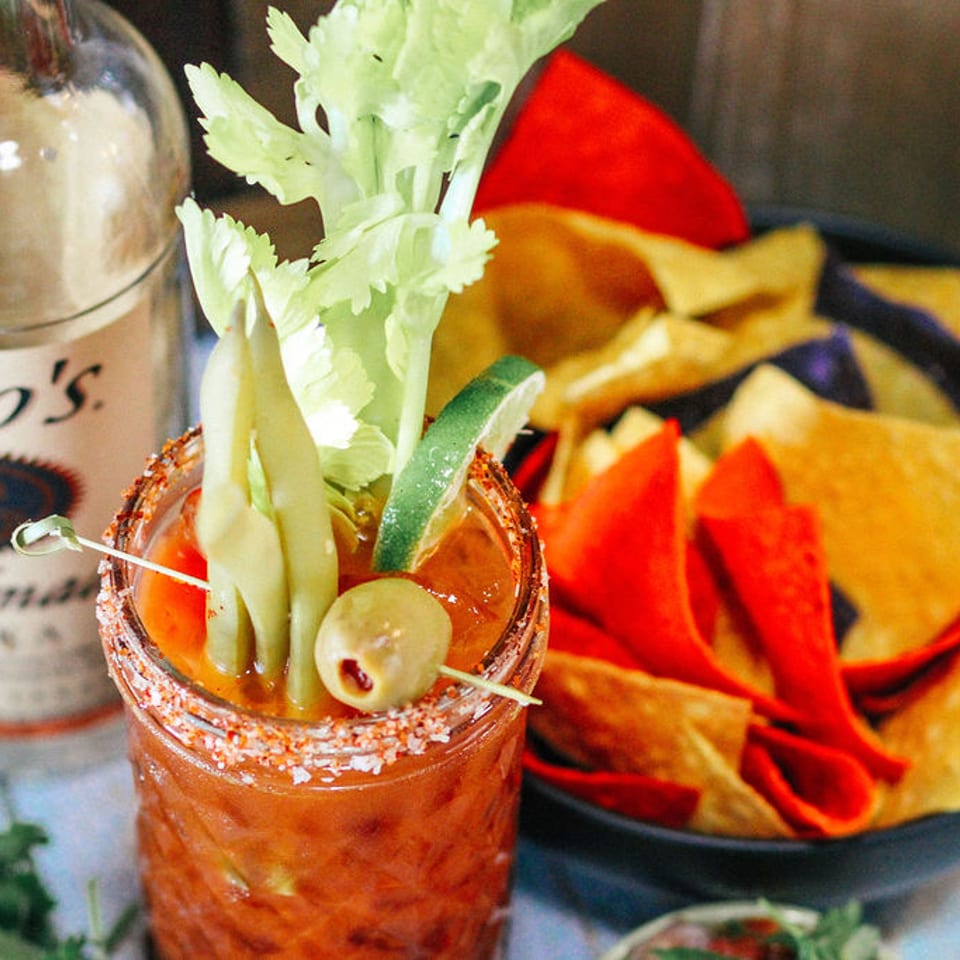 Garnished cocktail beside colorful tortilla chips at Corolla Cantina